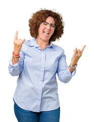 Beautiful middle ager senior businees woman wearing glasses over isolated background shouting with crazy expression doing rock symbol with hands up. Music star. Heavy concept.