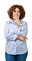 Beautiful middle ager senior businees woman wearing glasses over isolated background looking confident at the camera with smile with crossed arms and hand raised on chin. Thinking positive.