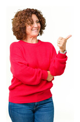 Wall Mural - Beautiful middle ager senior woman red winter sweater over isolated background Looking proud, smiling doing thumbs up gesture to the side