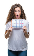 Sticker - Young brunette girl holding menstruation calendar over isolated background scared in shock with a surprise face, afraid and excited with fear expression