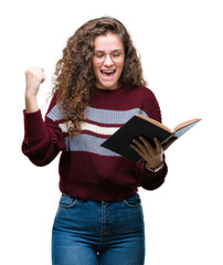 Young brunette girl reading a book wearing glasses over isolated background screaming proud and celebrating victory and success very excited, cheering emotion