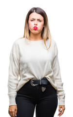 Sticker - Young beautiful woman casual white sweater over isolated background puffing cheeks with funny face. Mouth inflated with air, crazy expression.