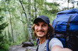 © Aleksey - A guy's smile, a selfie on the phone, a blogger shoots realms, video content for social networks, a hipster in a cap, a man on a hike with a backpack portrait of himself