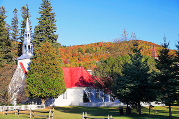 Wall Mural - Church surrounded by colorful autumn leaves at Mont Tremblant