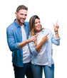 © Krakenimages.com - Young couple in love over isolated background smiling and looking at the camera pointing with two hands and fingers to the side.