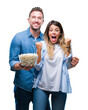 © Krakenimages.com - Young couple in love eating popcorn over isolated background screaming proud and celebrating victory and success very excited, cheering emotion