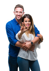 Wall Mural - Young couple in love over isolated background showing and pointing up with fingers number three while smiling confident and happy.