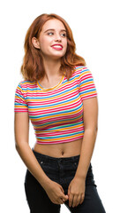 Wall Mural - Young beautiful woman over isolated background looking away to side with smile on face, natural expression. Laughing confident.