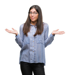 Wall Mural - Young beautiful hispanic business woman clueless and confused expression with arms and hands raised. Doubt concept.