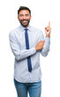 © Krakenimages.com - Adult hispanic business man over isolated background with a big smile on face, pointing with hand and finger to the side looking at the camera.