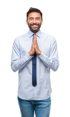 Canvas Print - Adult hispanic business man over isolated background praying with hands together asking for forgiveness smiling confident.