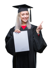 Poster - Young blonde woman wearing graduate uniform holding degree over isolated background very happy pointing with hand and finger to the side