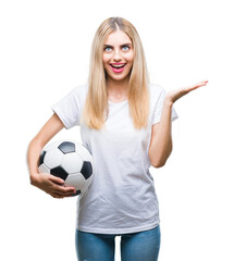 Sticker - Young beautiful blonde woman holding soccer ball over isolated background very happy and excited, winner expression celebrating victory screaming with big smile and raised hands