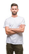 © Krakenimages.com - Young handsome man over isolated background skeptic and nervous, disapproving expression on face with crossed arms. Negative person.