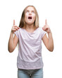 © Krakenimages.com - Young beautiful girl over isolated background amazed and surprised looking up and pointing with fingers and raised arms.