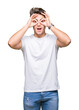 © Krakenimages.com - Young handsome man wearing white t-shirt over isolated background doing ok gesture like binoculars sticking tongue out, eyes looking through fingers. Crazy expression.