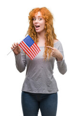 Sticker - Young redhead woman holding flag of United States of America very happy pointing with hand and finger