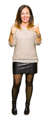 Wall Mural - Beautiful middle age woman wearing fashion sweater success sign doing positive gesture with hand, thumbs up smiling and happy. Looking at the camera with cheerful expression, winner gesture.