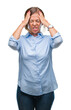 © Krakenimages.com - Middle age senior hispanic woman over isolated background suffering from headache desperate and stressed because pain and migraine. Hands on head.