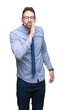 © Krakenimages.com - Young business man wearing glasses over isolated background hand on mouth telling secret rumor, whispering malicious talk conversation