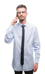 Canvas Print - Young business adult man talking on the phone with a confident expression on smart face thinking serious