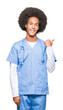 © Krakenimages.com - Young african american doctor man with afro hair smiling with happy face looking and pointing to the side with thumb up.