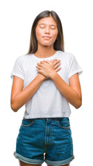 Sticker - Young asian woman over isolated background smiling with hands on chest with closed eyes and grateful gesture on face. Health concept.