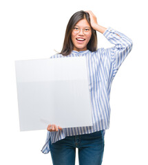 Sticker - Young asian woman over isolated background holding blank banner stressed with hand on head, shocked with shame and surprise face, angry and frustrated. Fear and upset for mistake.