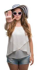 Poster - Young blonde woman wearing sunglasses and summer hat with open hand doing stop sign with serious and confident expression, defense gesture