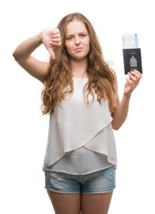 Sticker - Young blonde woman holding passport of canada and boarding pass with angry face, negative sign showing dislike with thumbs down, rejection concept