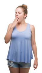 Wall Mural - Young blonde woman bored yawning tired covering mouth with hand. Restless and sleepiness.