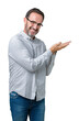 © Krakenimages.com - Handsome middle age elegant senior man wearing glasses over isolated background Pointing to the side with hand and open palm, presenting ad smiling happy and confident