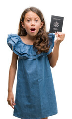 Poster - Brunette hispanic girl holding passport of United States of America scared in shock with a surprise face, afraid and excited with fear expression