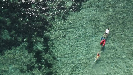 Wall Mural - Aerial view of family father and daughter snorkeling together in clear turquoise water ttop view. Vacation, travel concept