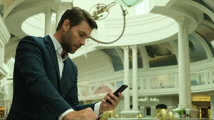 message concept, busy businessman using auto respond app to sms notification. businessman in formal suit looking at screen of cell mobile phone. American man typing a message on smartphone outdoors