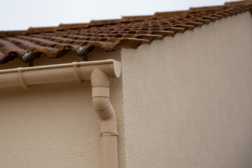 Wall Mural - plastic edge of a roof gutter with clips and edge of shingles