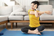 © Natee Meepian - Attractive young woman doing yoga stretching yoga online at home. Self-isolation is beneficial. Healthy lifestyle concept