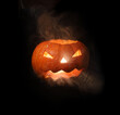 Halloween pumpkin and smoke on black background.