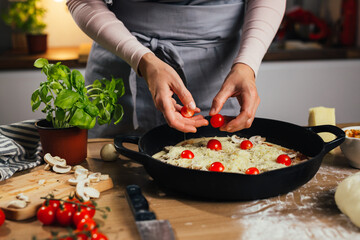 woman preparing home made pizza in kitchen