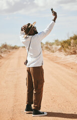 Wall Mural - Selfie, black man and outdoor with summer look travelling on dirt road being relax, cool or countryside on safari or holiday. Smartphone, African American male and vacation adventure, relax or happy.