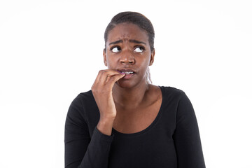 Wall Mural - Portrait of anxious African American woman. Worried young model in black shirt with ponytail looking away, biting nails. Anxiety, stress concept.