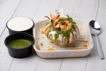 Rajasthani Shahi Raj-Kachori, stuffed with potato and sprout filling. served with curd, chutney and sev in a plate