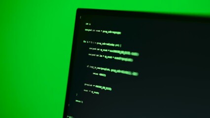 Wall Mural - programming code running on computer screen in a dimly lit room. close up