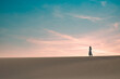 © ADDICTIVE STOCK - woman walking on sandy dune in sunset