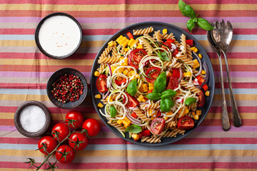 Wall Mural - healthy pasta salad with zucchini sweet corn tomato and basil, vegetarian lunch