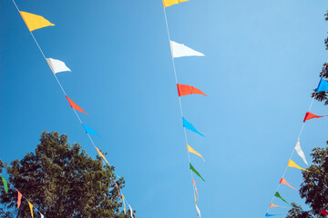 Triangle flags hanging in a row with blue sky