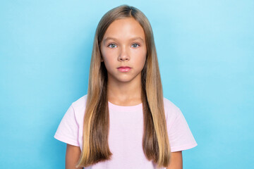 Poster - Photo of nice lovely school girl with straight hairstyle wear white t-shirt serious looking at camera isolated on blue color background