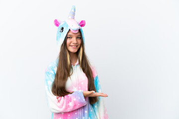 Poster - Little caucasian girl wearing unicorn pajama isolated on white background presenting an idea while looking smiling towards