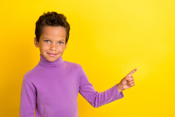 Wall Mural - Photo portrait of cute little pupil boy point useful tips information poster wear trendy violet outfit isolated on yellow color background