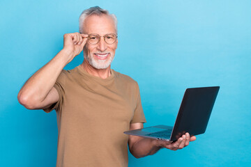 Sticker - Photo of positive intelligent retired person hold eyewear modern device enjoy using gadget empty space isolated on blue color background